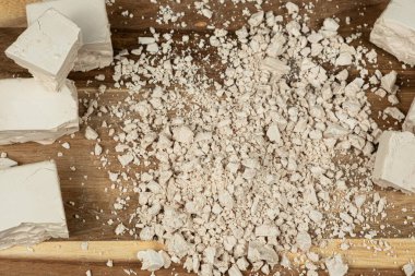 Sıkıştırılmış taze maya küpleri ahşap arka planda yakın plan.