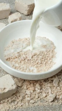 Sıcak sütte taze mayayı eritme süreci, yemek tarifi, dikey yavaş çekim..