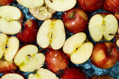 Sulu Tüm Elmalar ve Kesilen Kırmızı Elmalar Su Sıçratma Üst Görünümü.