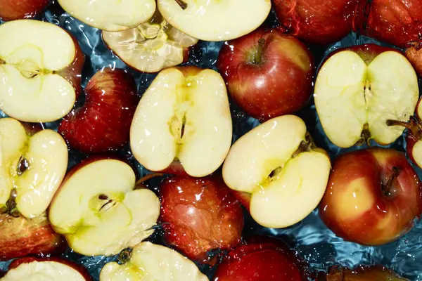 Sulu Tüm Elmalar ve Kesilen Kırmızı Elmalar Su Sıçratma Üst Görünümü.