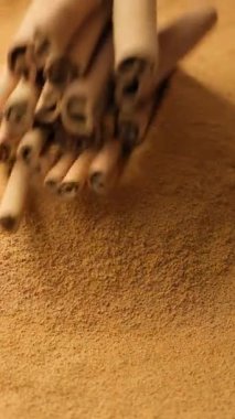 Tarçın çubukları tarçınlı yere düşey yavaş çekim makrosu ile düşer.