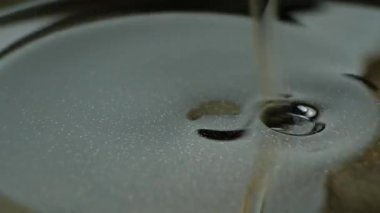 Bitkisel yağ döküm demir tava makro işlem yavaş çekim içine dökülür.