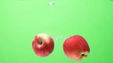 Düşen kırmızı elmaların sualtı görüntüsü. Sudaki Meyveler Yavaş Harekette.