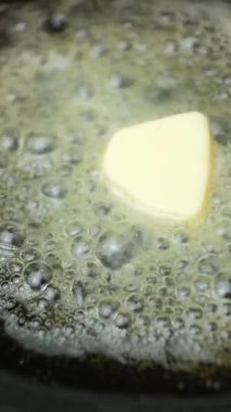 Tereyağı bir tavada erir, tereyağında yavaş çekimde dikey kızarma işlemi