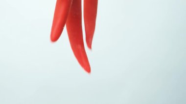 Baloncuklarla berrak suya dökülen baharatlı biberler.