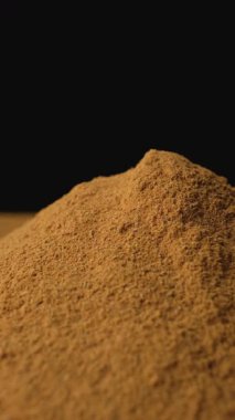 Yer tarçın tozu yakın plan. Aromatik baharat dokusu. Dikey Atış Döndürme.