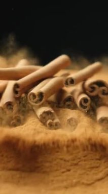 Tarçın çubukları tarçınlı yere düşey yavaş çekim makrosu ile düşer..