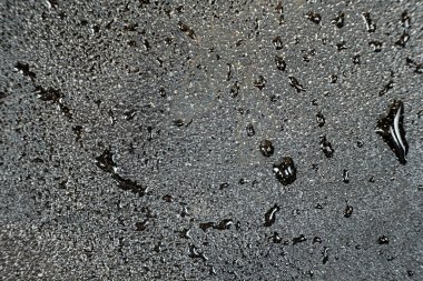 Demir bir makro yüzeyde su damlacıkları. Demir tencere bakımı, pas direnci, soyut desen.