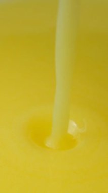 Taze pişmiş ghee berrak tereyağı dökülen makro doku dikey ağır çekim.