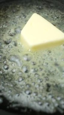 Tereyağı bir tavada erir, tereyağında yavaş çekimde dikey kızarma işlemi.