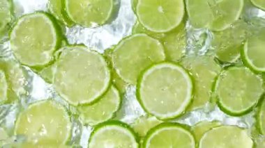 Taze yaz arkaplan dilimleri suda taze limonlar, yavaş çekimde su sıçraması..