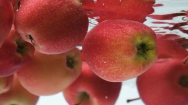 Yüzen kırmızı elmaların estetik sualtı görüntüsü.