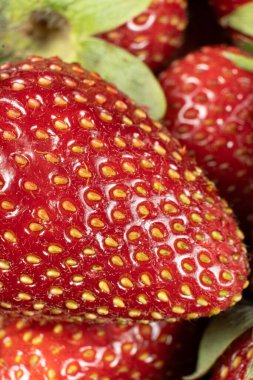 Olgun taze çilek makrosu, temiz tahıllar, dikey meyve arkaplanı..