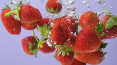 Taze çilek suya batırılmış, su sıçramış, bir sürü kabarcık, ağır çekim.
