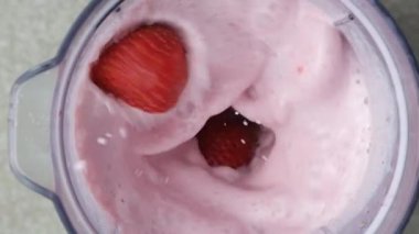 Blender kasesine düşen taze çilekler, milkshake yapıyor, yavaş çekim.
