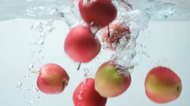 Sulu kırmızı elmalar suya düşüyor. Yavaş Hareket Sıçraması