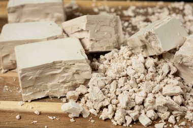 Sıkıştırılmış taze maya küpleri ahşap arka planda yakın plan