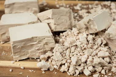 Sıkıştırılmış taze maya küpleri ahşap arka planda yakın plan