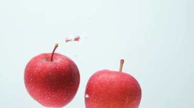İki Kırmızı Taze Elma Yavaş Meyve Suyunda Dönüyor.