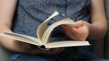 Kalın kitabın sayfalarını çeviren kadın, yavaş çekimde yakın plan..