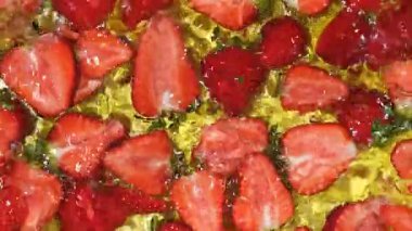 Suda taze çilek parçaları, biraz su, üst manzara, yavaş çekim..