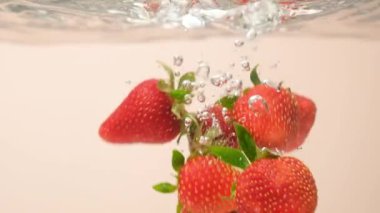 Suyun içinde canlı bir çilek. Dramatik Su Sıçratma ve Yüzen Baloncuklar