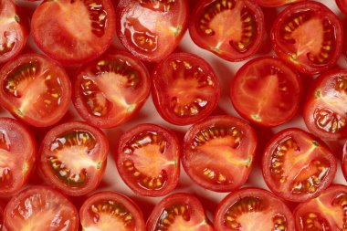 Küçük olgun domatesler ikiye bölünmüş makro üst görünüm.