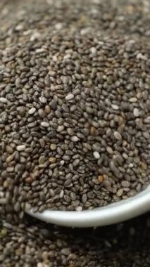 Chia tohumları kaşıktan dökülüyor, makro dikey yavaş çekim.