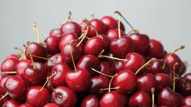 Olgun kiraz yığını, tatlı kirazları su damlacıklarıyla yıkadı, yavaşça döndü..