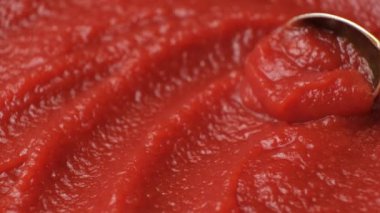 Bir kaşıkta konsantre doğal domates ezmesi, makro doku yavaş çekim.
