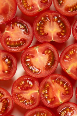 Küçük olgun domatesler ikiye bölünmüş makro üst görünüm.