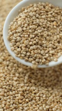 Beyaz kinoa kaşıktan dökülüyor, makro yavaş çekim dikey.