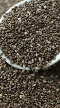 Chia tohumları kaşıktan dökülüyor, makro dikey yavaş çekim.
