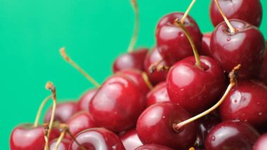 Olgun kiraz yığını, tatlı kirazları su damlacıklarıyla yıkadı, yavaşça döndü..