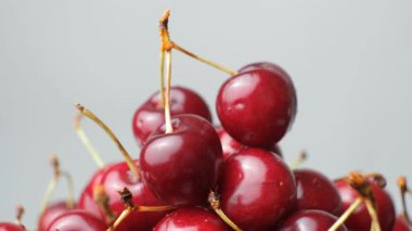 Olgun kiraz yığını, tatlı kirazları su damlacıklarıyla yıkadı, yavaşça döndü..