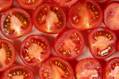 Küçük olgun domatesler ikiye bölünmüş makro üst görünüm.