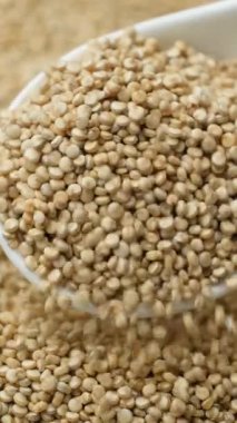 Beyaz kinoa kaşıktan dökülüyor, makro yavaş çekim dikey.