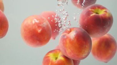 Taze şeftaliler berrak suya sıçrıyor Yavaş Harekete geçiyor.