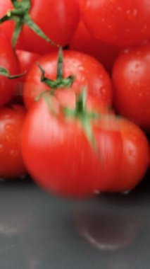 Taze olgun domates yavaş çekimde düşüyor, suyu dikey sıçratıyor.