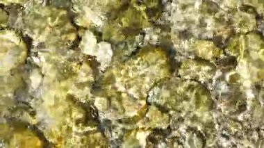 Nehir yatağı taşlarının yavaş çekimde akan suyun soyut görüntüsü, Üst Görünüm.