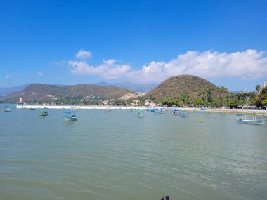 View of the pier and the lighthouse in Chapala with some boats, Mexico