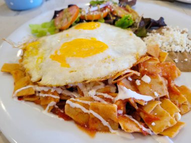 Chilaquiles, sahanda yumurta, fasulye ve salata ile geniş bir manzara.