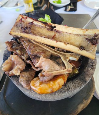 Geleneksel molcajete kasesi çeşitli ızgara etler ve zengin salsa sosuyla dolu.