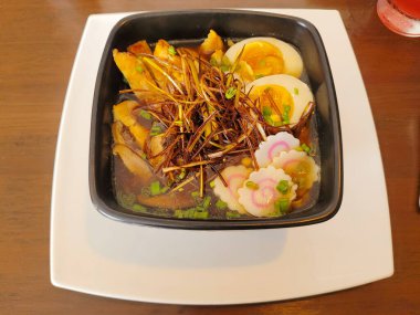 Baharatlı yumurta, mantar ve çıtır soğan ile süslenmiş gurme ramen.