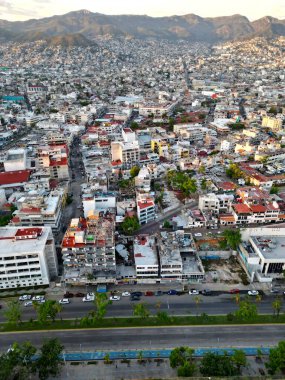 Yüksek açılı dikey fotoğraf Acapulco 'nun canlı ve hareketli merkezini yakalıyor, yoğun kentsel manzarasını sergiliyor