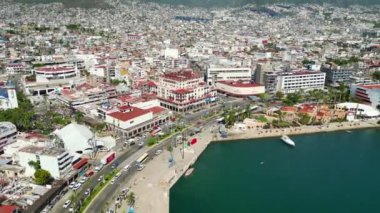 Acapulco 'nun hareketli şehir merkezinin kıyı kesiminde sahili ve kentsel alanını gösteren nefes kesici bir insansız hava aracı yolculuğu.