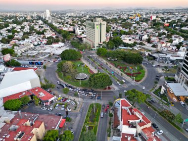 Geniş yatay hava manzarası Guadalajara 'nın hareketli caddeleriyle çevrili Glorieta de los Caballos' u yakalıyor.