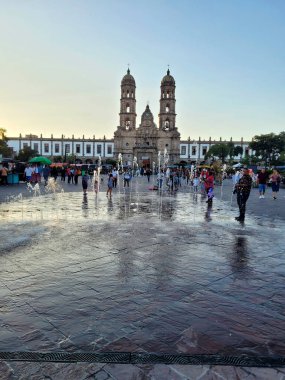 Zapopan Bazilikası 'nın zemin olarak kullanıldığı hareketli plaza çeşmesinin akşam manzarası