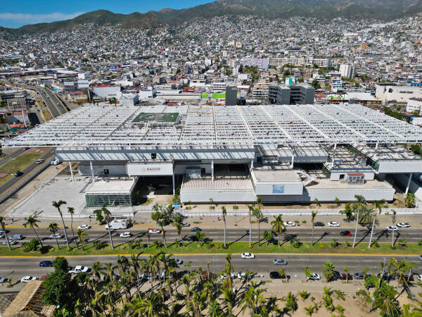 Снимок с воздуха, показывающий Секретариат здравоохранения в Акапулько, устойчивый посреди городского ландшафта после прохождения Отисса