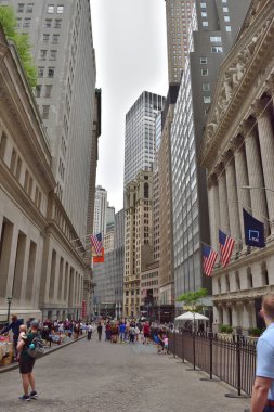 New York, ABD - 13 Mayıs 2023: Wall Street, New York 'un finans bölgesinin enerjisini kapsayan yüksek binalarla çevrili olarak faaliyetlerle çalkalanıyor.